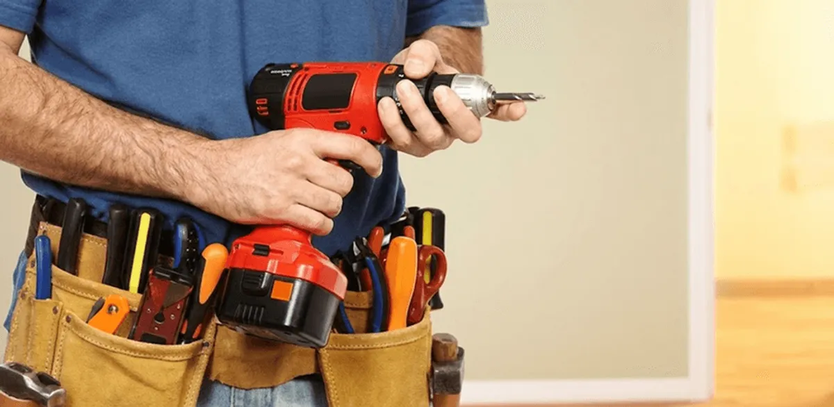 Handyman holding a power drill for home repairs and installations in Nashua, NH